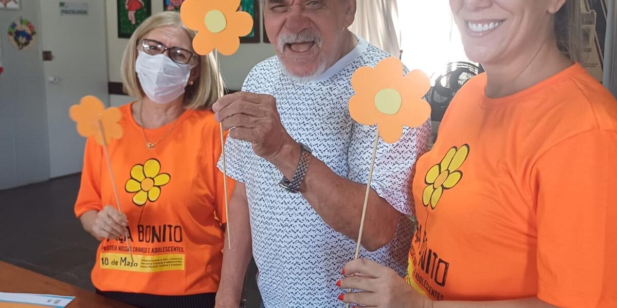 Funcionários e Idosos Montando as Flores Funcionária e idoso exibindo as flores montadas